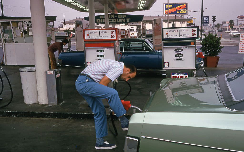 View of unidentified motorists refueling at a coin-operated gas station, Los Angeles, California, October 5, 1973.