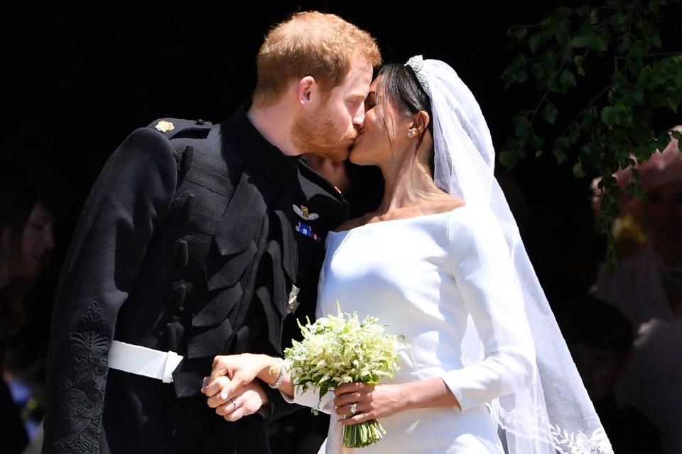 windsor, united kingdom   may 19 britains prince harry, duke of sussex kisses his wife meghan, duchess of sussex as they leave from the west door of st georges chapel, windsor castle, in windsor on may 19, 2018 in windsor, england photo by  ben stansall   wpa poolgetty images