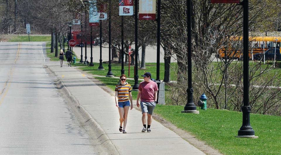 Edinboro University students walk around Mallory Lake on April 8 at the campus in Edinboro, Pa.