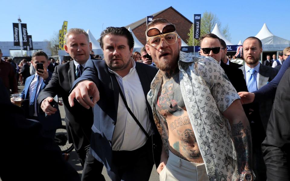 Conor McGregor, centre-right, arrives at Aintree Racecourse on Saturday afternoon - PA