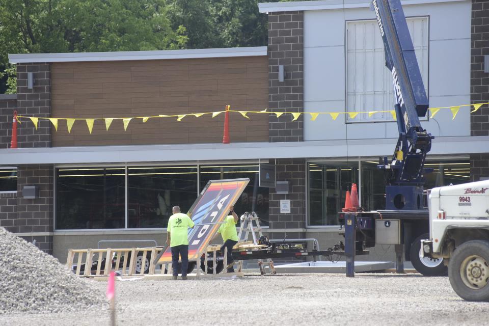 Workers move the Aldi sign outside the new Bucyrus location in early August.