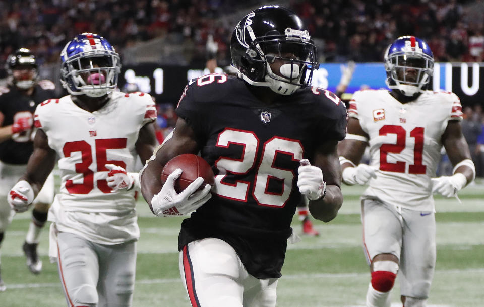 Tevin Coleman, corredor de los Falcons de Atlanta, anota delante de Curtis Riley (35) y Landon Collins, de los Giants de Nueva York, durante el encuentro del lunes 22 de octubre de 2018 (AP Foto/John Bazemore)