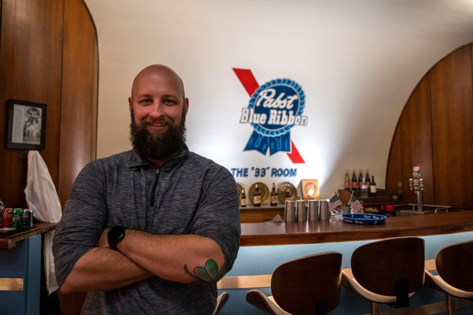 Dustin Crawford, owner and cocktail crafter at The 33 Room, poses inside the bar in Peoria Heights on Dec. 15, 2021.