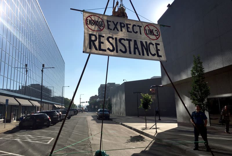 FILE PHOTO: An activist opposing the Enbridge Line 3 oil pipeline dangles from a steel structure erected in St. Paul