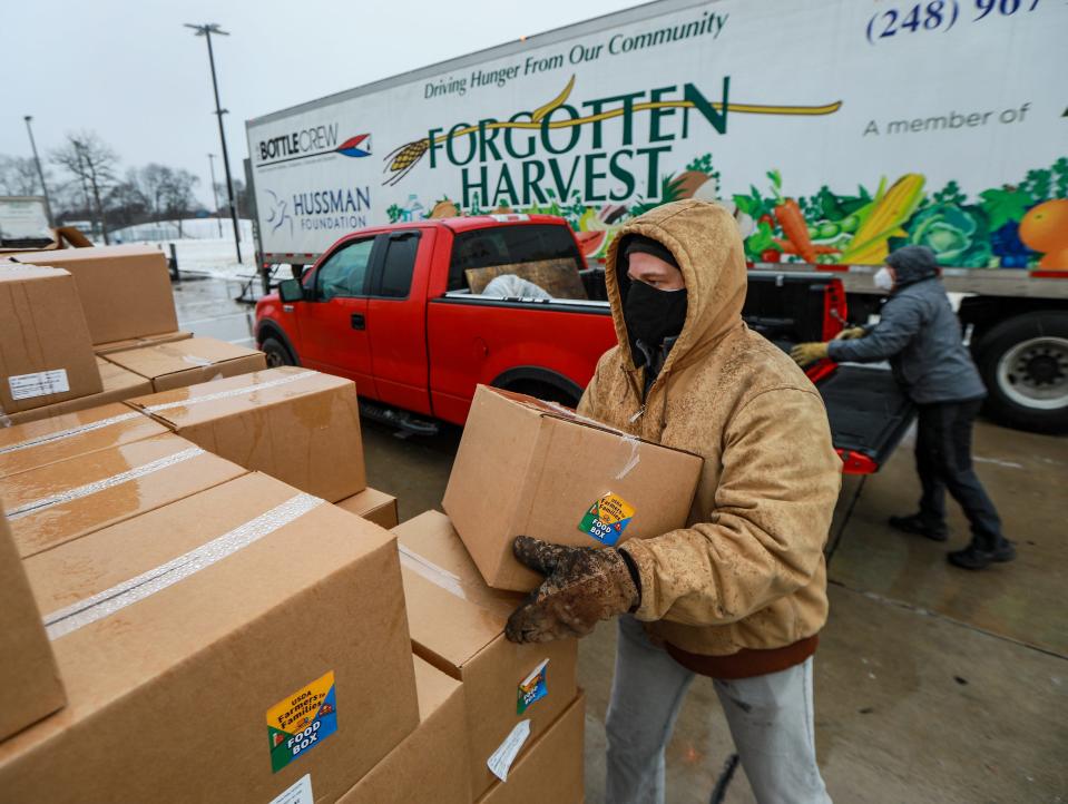 Jason Schwegler, 47, of Grand Blanc, places boxes of food into vehicles at the Forgotten Harvest Mobile Pantry at Oak Park recreation center in Oak Park on Dec. 30, 2020.