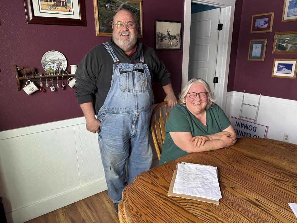 Dan and Sue McLean are pictured at their kitchen table on Wednesday, March 6, 2024, at their home near Menoken, N.D. On the table are papers from Summit Carbon Solutions, which has proposed a multistate pipeline that would bury CO2 emissions deep underground in North Dakota. The McLeans, like other landowners around the Midwest, are opposed to the pipeline. (AP Photo/Jack Dura)