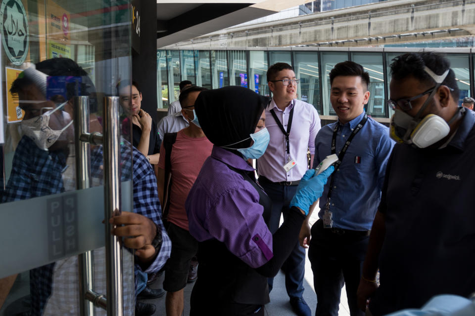 People having their temperature taken before entering a McDonald's outlet in Kuala Lumpur's Bukit Bintang area on 18 March 2020, the first day of the Movement Control Order. (PHOTO: Fadza Ishak for Yahoo Malaysia)