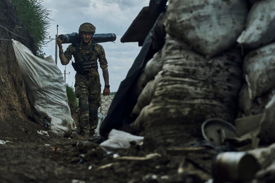 A Ukrainian soldier carries supplies in a trench at the frontline near Bakhmut (Copyright 2023 The Associated Press. All rights reserved.)