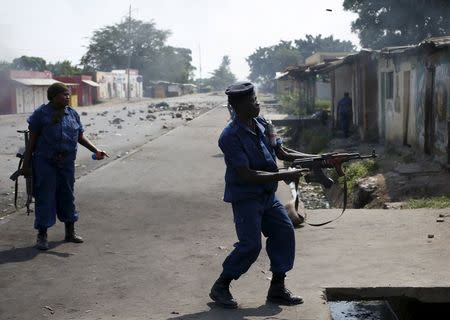 A policeman fires his AK-47 rifle during a protest against President Pierre Nkurunziza's decision to run for a third term in Bujumbura, Burundi, May 29, 2015. REUTERS/Goran Tomasevic