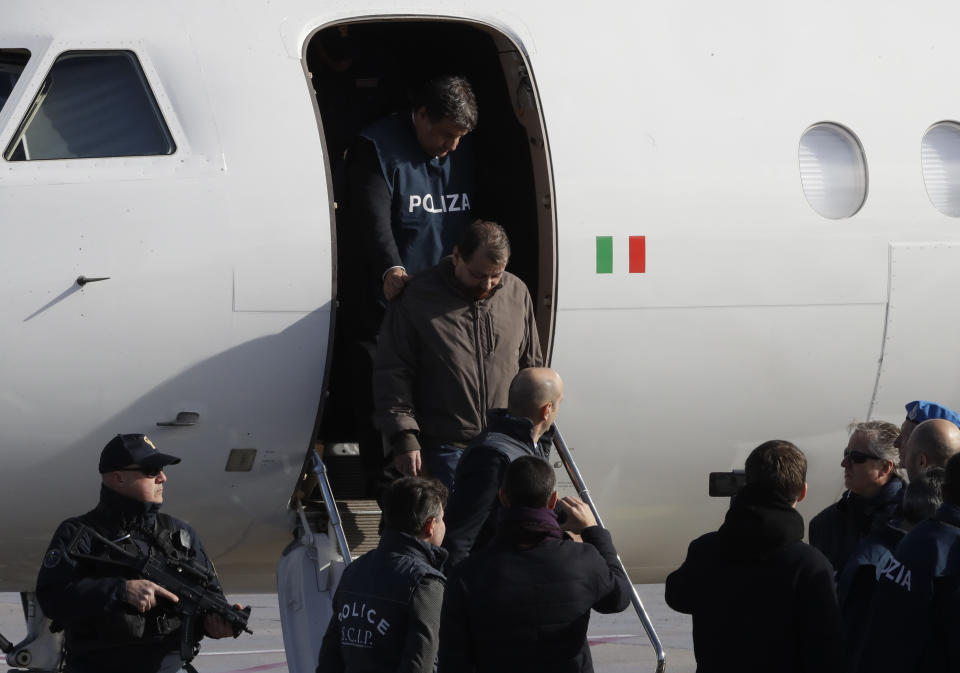 Italian fugitive Cesare Battisti arrives at Ciampino military airport, in Rome, Monday, Jan. 14, 2019. Battisti a left-wing Italian militant who was convicted of murder three decades ago is heading home to serve a life sentence, after his life as a celebrity fugitive came to an abrupt end with his arrest in Bolivia by a team of Interpol agents. (AP Photo/Alessandra Tarantino)