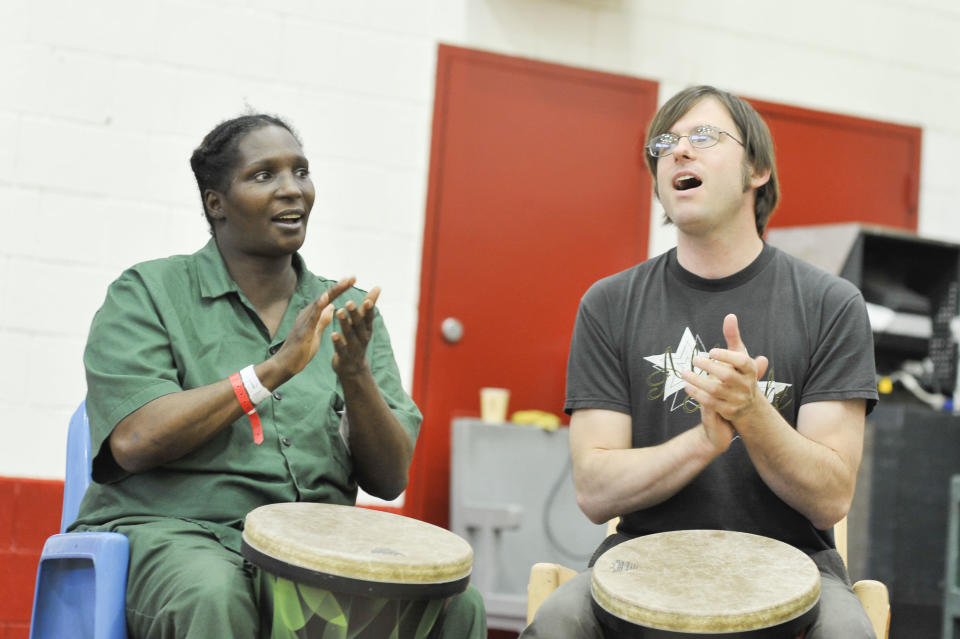 Inmate Alitha Jackson and volunteer John Colpitts clap and sing along.