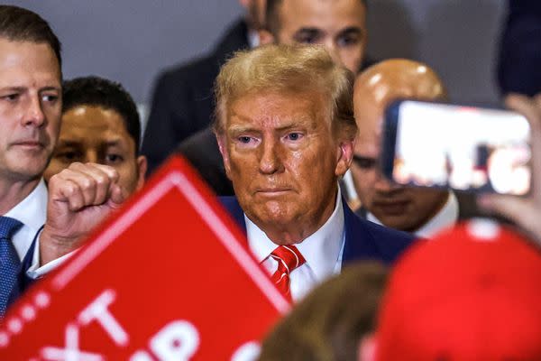 A picture of former US President Donald Trump standing at a campaign rally with sweat and an orange color on his face was shared online in January 2024.