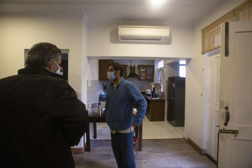 Agence France-Presse’s Kashmir correspondent Parvaiz Bukhari, centre, talks to his colleagues after National Investigation Agency personnel searched his premises on the outskirts of Srinagar, Indian controlled Kashmir, Wednesday, Oct. 28, 2020. (AP Photo/Mukhtar Khan)