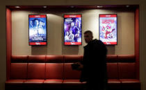 A man walks past a poster (C) of the movie "Going Vertical" at a cinema in Moscow, Russia January 22, 2018. Picture taken January 22, 2018. REUTERS/Tatyana Makeyeva