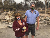 Kevin Conant and his wife, Nikki, look at the debris of their home and business "Conants Wine Barrel Creations," after the Glass/Shady fire completely engulfed it, Wednesday, Sept. 30, 2020, in Santa Rosa, Calif. The Conants escaped with their lives, which we are grateful for, but they barely made it out with the clothes on their backs in the wake of the fire. The Glass and Zogg fires are among nearly 30 wildfires burning in California. (AP Photo/Haven Daley)