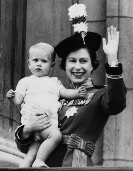 <p>The Queen waves with her son, Prince Edward, in her arms.</p>