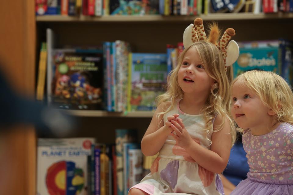 Sister Claire and Maddie Prillaman listen to author Debra Young Hatch read at the "Giraffes in My Closet" book reading at Barnes & Noble Friday, June 21, 2024.