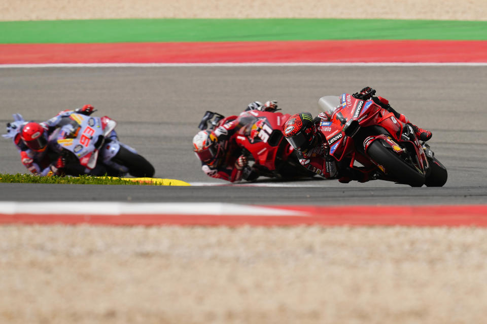 MotoGP rider Francesco Bagnaia of Italy, right, takes a curve followed by Pedro Acosta of Spain and Marc Marquez, also of Spain, left, during the Portuguese Motorcycle Grand Prix at the Algarve International circuit near Portimao, Portugal, Sunday, March 24, 2024. (AP Photo/Jose Breton)