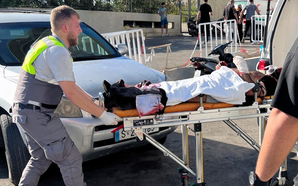 Civil Defense first-responder carries a wounded man whose handheld pager exploded at al-Zahraa hospital in Beirut, Lebanon