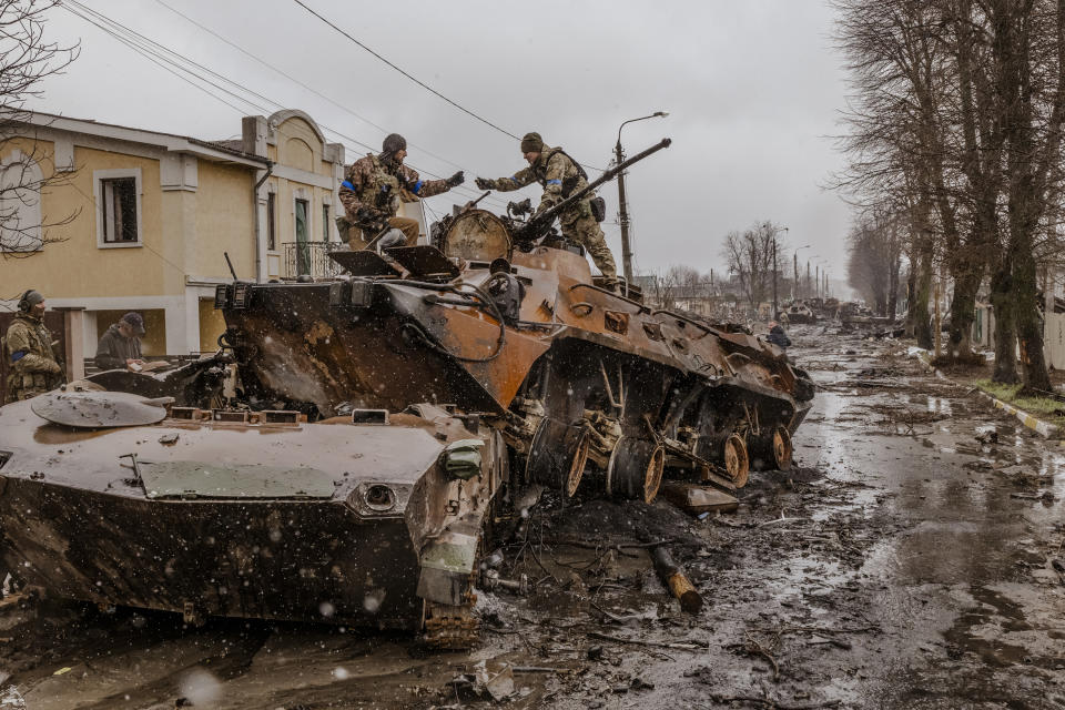 Soldados ucranianos recuperan piezas de un vehículo militar ruso destruido en Bucha, Ucrania, el 3 de abril de 2022. (Daniel Berehulak/The New York Times).