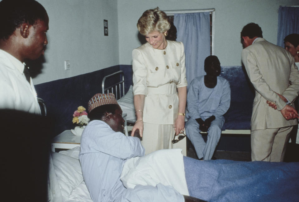 Diana, Princess of Wales (1961-1997), wearing a Catherine Walker suit, and her husband, Charles, Prince of Wales, with an patient during a visit to the Molai Centre, a leprosy hospital and rehabilitation village in Maiduguri, Nigeria, 17th March 1990. The Royal couple are on a five-day visit to Nigeria.