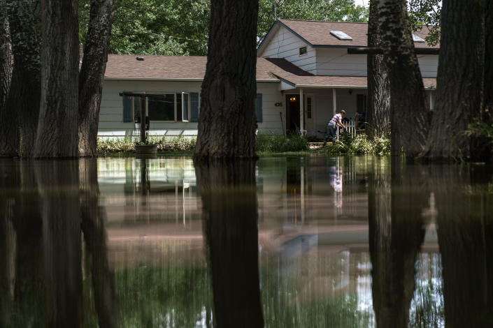 Aileen Rogers helps clean out a friend's house badly damaged by the severe flooding in Fromberg, Mont., Friday, June 17, 2022. (AP Photo/David Goldman)