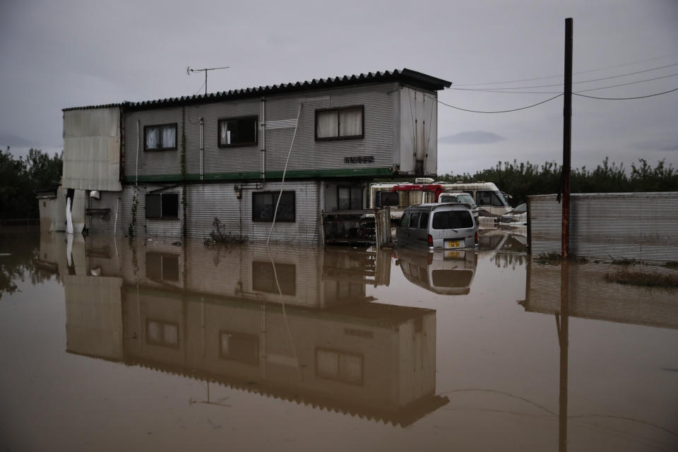 A building is surrounded by floodwaters Monday, Oct. 14, 2019, in Hoyasu, Japan. Rescue crews in Japan dug through mudslides and searched near swollen rivers Monday as they looked for those missing from a typhoon that left as many as 36 dead and caused serious damage in central and northern Japan. (AP Photo/Jae C. Hong)