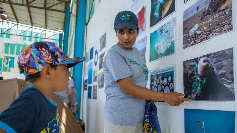 Bedolla mostrando una imagen de especies locales a un niño