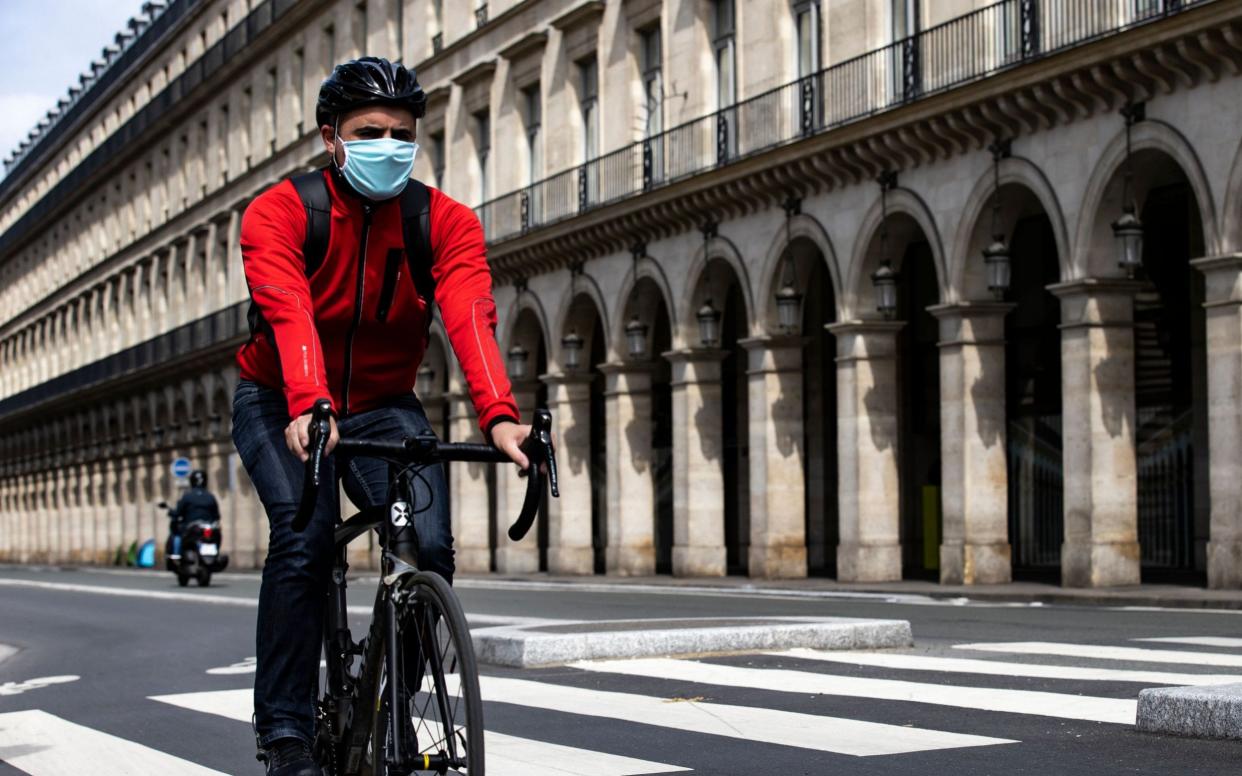  A man cycles down Rue de Rivoli in Paris, France - IAN LANGSDON/EPA-EFE/Shutterstock