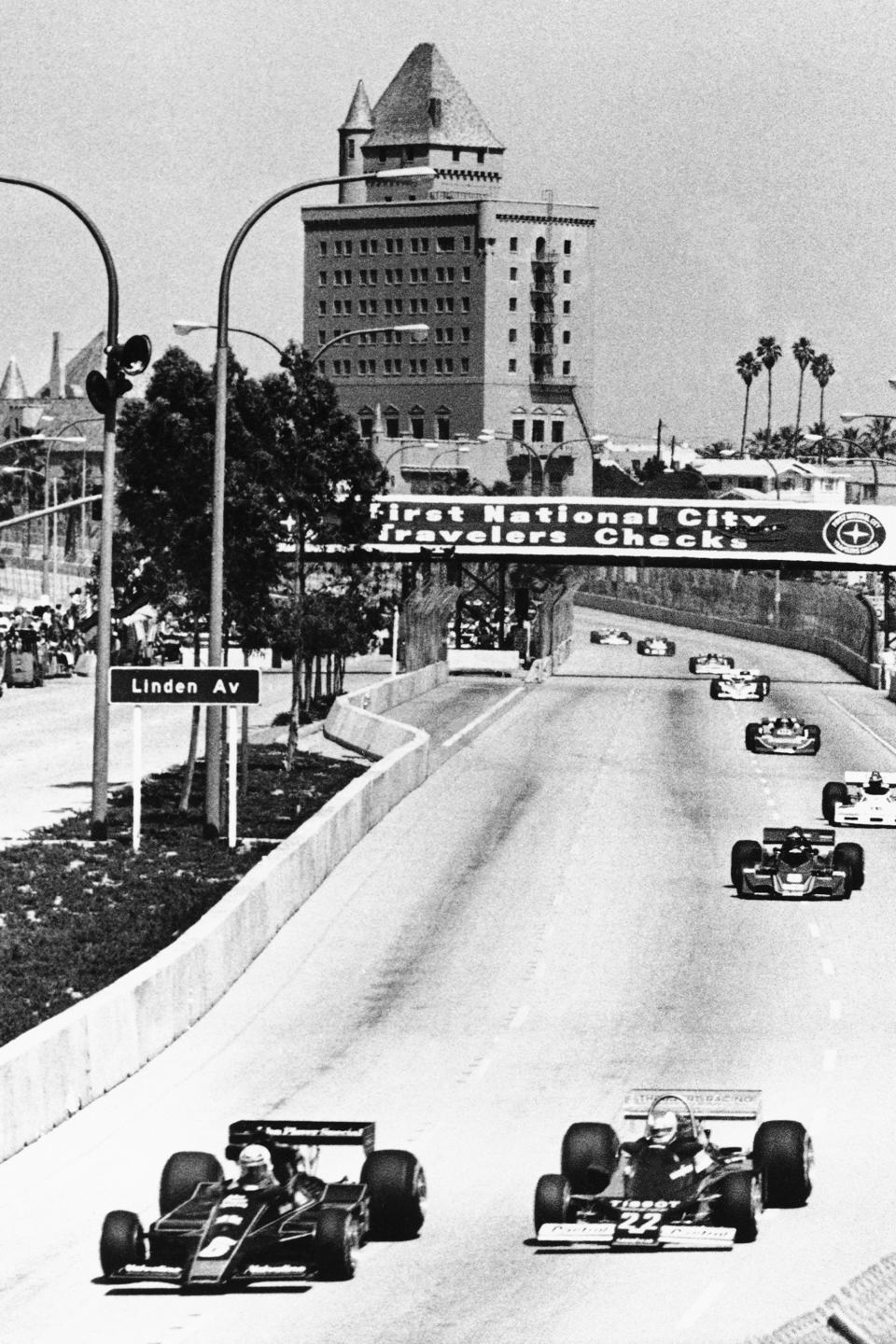 FILE - Formula One drivers Mario Andretti, left, and Clay Regazzoni of Switzerland lead the field through the streets of Long Beach, Calif., during the early laps of the Long Beach Grand Prix, in this April, 3, 1977, file photo. The Grand Prix of Long Beach opens 17 months after the pandemic ended the crown jewel's streak as one of the longest continuously-running street events in racing. The city closed its downtown streets for the first time in 1975 to host a street race that became one of the most prestigious events in both motorsports but also for successful, annual festivals (AP Photo/File)