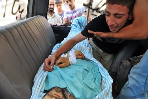 A Syrian man mourns over the body of a friend killed during clashes between Syrian troops and rebels in the northern city of Aleppo. Rebels accused strongman Bashar al-Assad on Tuesday of moving chemical weapons to Syria's borders, a day after his beleaguered regime said it would use its stockpiles if attacked