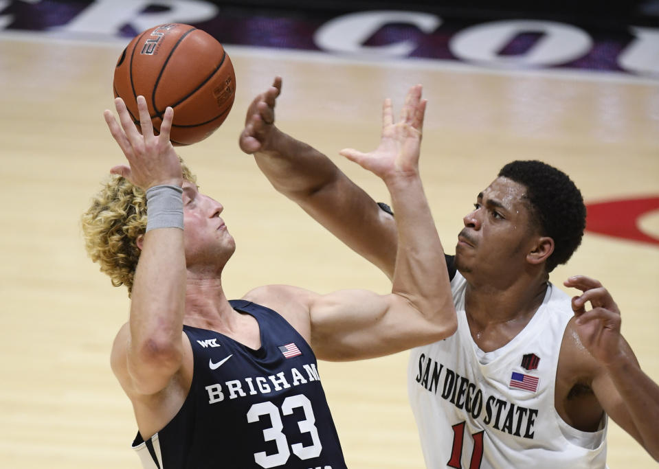 BYU forward Caleb Lohner (33) fights for the ball with San Diego State forward Matt Mitchell (11) during the second half of an NCAA college basketball game Friday, Dec. 18, 2020, in San Diego. (AP Photo/Denis Poroy)