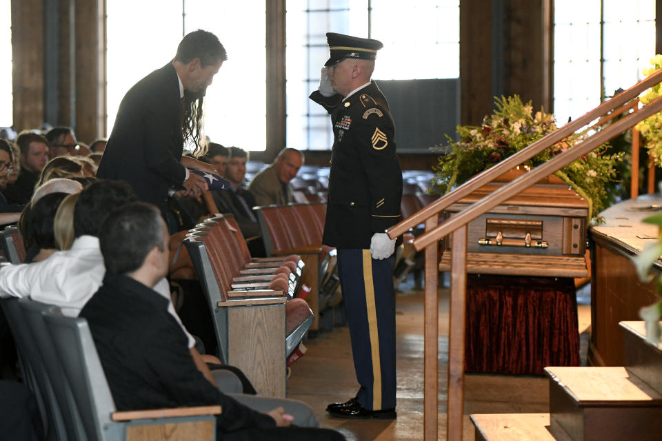 Thomas Howell and Natalie Henry-Howell, parents of Riley Howell, are saluted by a military honor guard after receiving his flag during a memorial service for their son in Lake Junaluska, N.C., Sunday, May 5, 2019. Family and hundreds of friends and neighbors are remembering Howell, a North Carolina college student credited with saving classmates' lives by rushing a gunman firing inside their lecture hall. (AP Photo/Kathy Kmonicek)