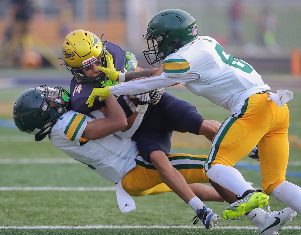 Copley receiver Caleb Wisniewski is taken down by Firestone defenders Juelz Causby, left, and Brandon Foster on Friday in Copley.