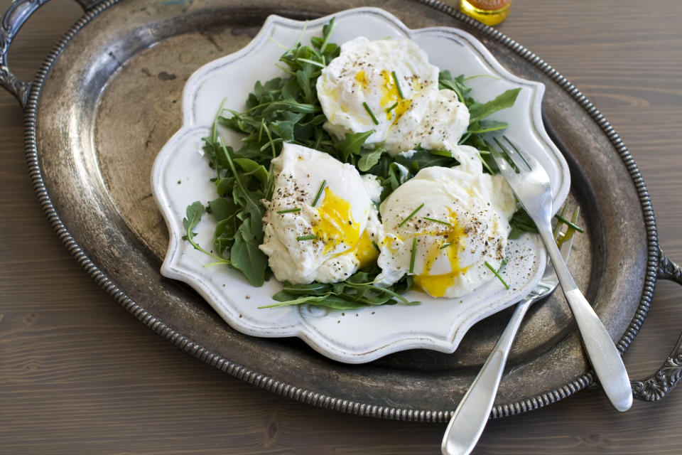 In this image taken Dec. 3, 2012, poached eggs over ricotta cheese on arugula are shown served on a plate in Concord, N.H. (AP Photo/Matthew Mead)