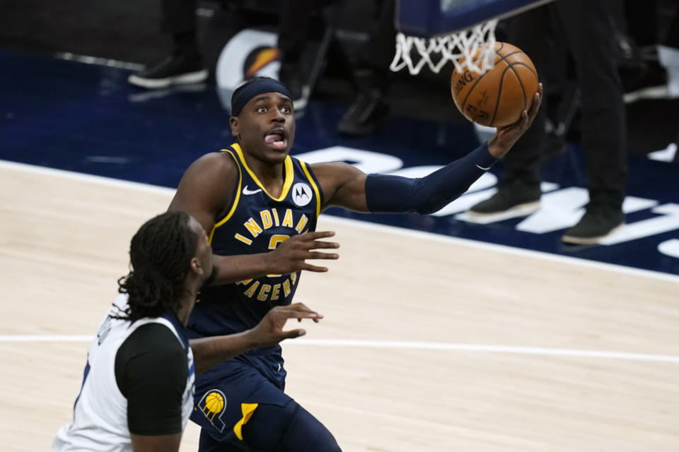 Indiana Pacers' Aaron Holiday (3) puts up a shot against Minnesota Timberwolves' Naz Reid (11) during the second half of an NBA basketball game, Wednesday, April 7, 2021, in Indianapolis. (AP Photo/Darron Cummings)