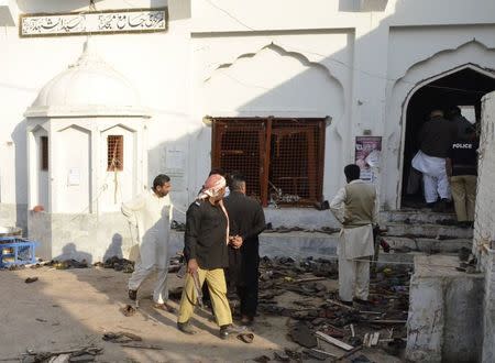 Residents and police stand among victims' shoes after an explosion in a Shi'ite mosque in Shikarpur, located in Pakistan's Sindh province January 30, 2015. REUTERS/Amir Hussain