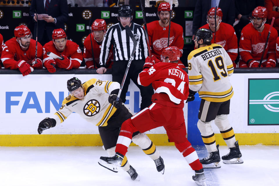 Detroit Red Wings' Klim Kostin (24) checks Boston Bruins' Patrick Brown, left, during the first period of an NHL hockey game Saturday, Oct. 28, 2023, in Boston. (AP Photo/Michael Dwyer)