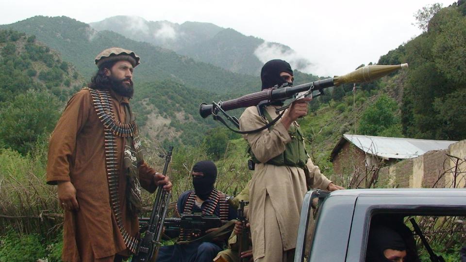 FILE - In this file photo taken on Aug. 5, 2012, Pakistani Taliban patrol in their stronghold of Shawal in Pakistani tribal region of South Waziristan. Secret contacts are again reported to be underway for an Afghanistan peace deal, but neither analysts nor the belligerents see hope they will succeed. (AP Photo/Ishtiaq Mahsud, File)