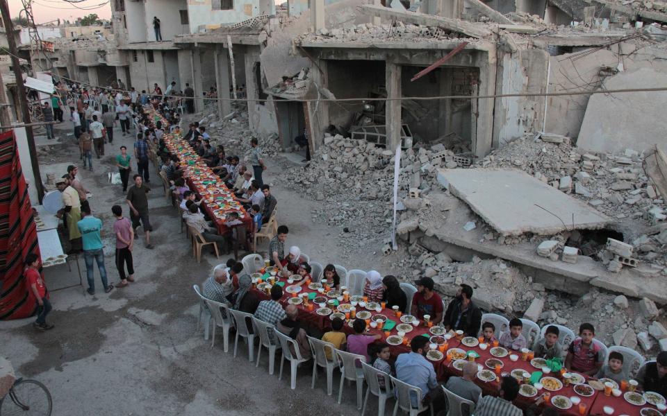 Syrian residents of the rebel-held town of Douma, on the outskirts of the capital Damascus, break their fast with the