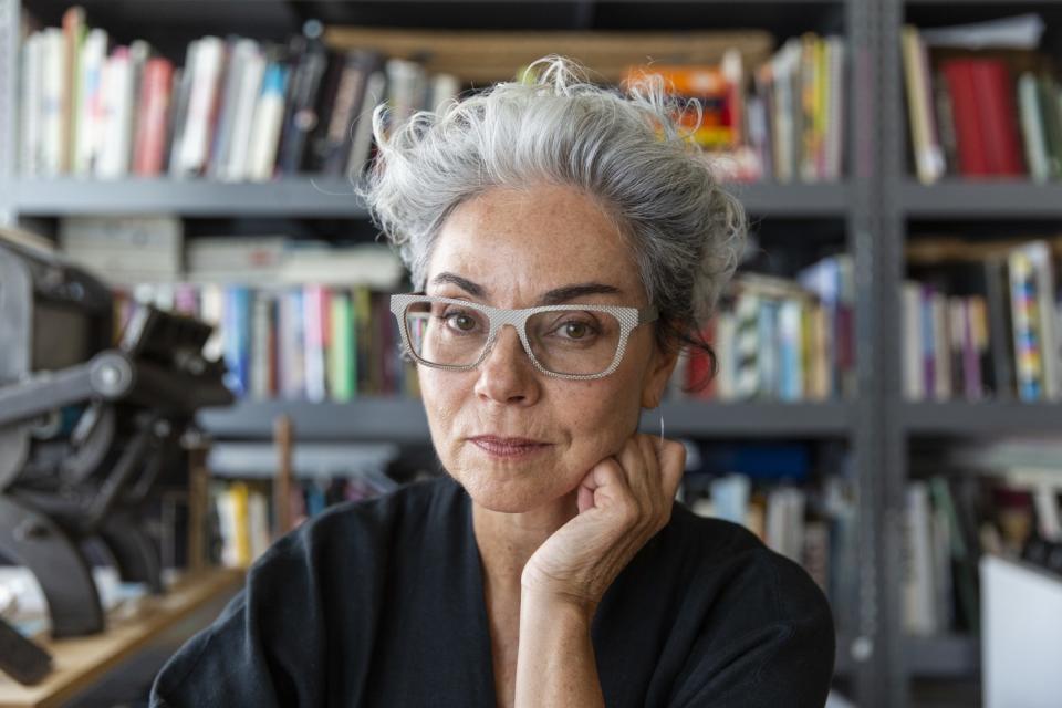 Artist and designer Rebeca Méndez in her book lined studio