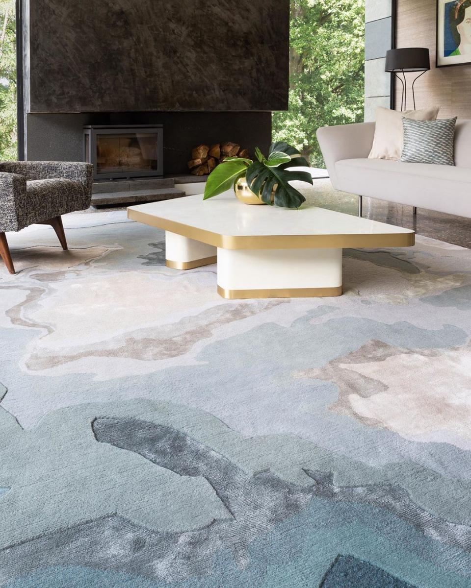 a white table with a plant on it in front of a fireplace