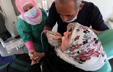 Dentist treats displaced Syrian refugee at mobile dental clinic near Azaz