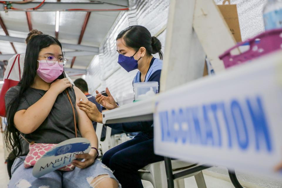 A girl is inoculated with a COVID-19 vaccine at a sports complex in Marikina City, the Philippines on Nov. 29, 2021. The Philippines on Monday started a three-day vaccination campaign to speed up the immunization of the country's population against COVID-19 and its Omicron variant. (Photo: Rouelle Umali/Xinhua via Getty Images)