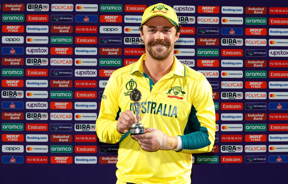 Travis Head poses with a trophy.