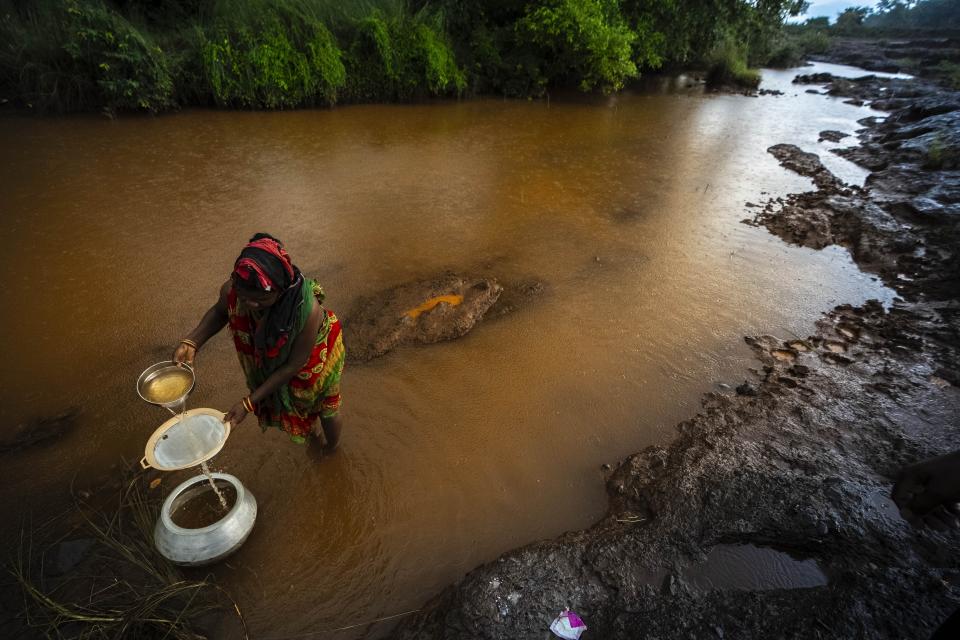 A villager collects drinking water from the Damsala River near chromium mines at Kaliapani village in Jajpur district, Odisha, India on Thursday, July 6, 2023. Kaliapani is impoverished, has barely any access to clean water and residents claim their chronic overexposure to chromium has caused lasting health problems. (AP Photo/Anupam Nath)