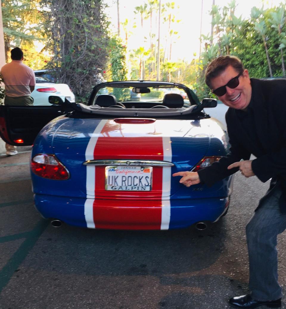 Brian Allan is a loyal customer of Reviver. Here, a valet takes a picture of Allan with his 2002 Jaguar XK8  convertible used in the movie “Austin Powers in Goldmember.” Allan will replace the regular license plate with a digital plate.