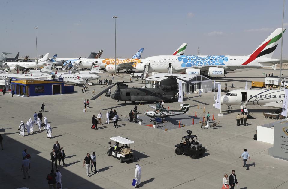 People visit planes during the opening day of the Dubai Airshow, in Dubai, United Arab Emirates, Sunday, Nov. 17, 2019. The biennial airshow opened as major Gulf airlines rein back big-ticket purchases after a staggering $140 billion in new orders were announced at the 2013 show before global oil prices collapsed. (AP Photo/Kamran Jebreili)