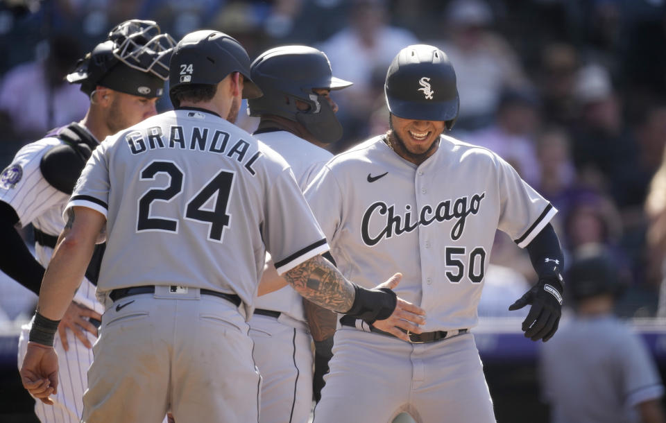 Chicago White Sox's Yasmani Grandal (24) congratulates Lenyn Sosa (50) who crosses home plate after hitting a three-run home run off Colorado Rockies relief pitcher Justin Lawrence in the eighth inning of a baseball game Sunday, Aug. 20, 2023, in Denver. (AP Photo/David Zalubowski)