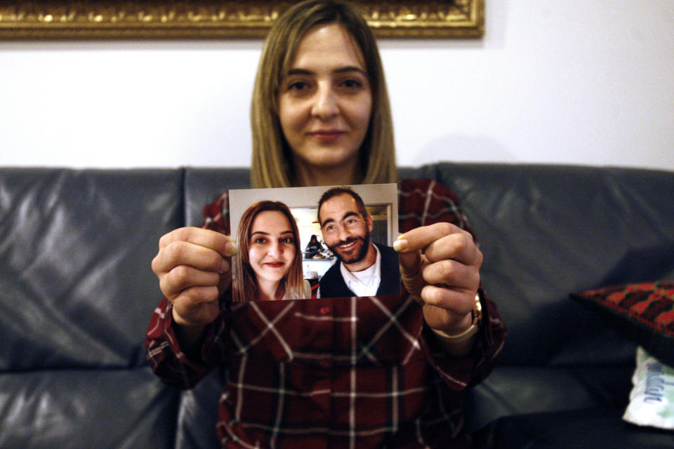 In this July 30, 2019, photo, Aya Al-Umari, whose brother Hussein was killed in the Christchurch mosque attacks, poses, holding a photo of herself and her brother, in Christchurch, New Zealand. She is among 200 survivors and relatives from the Christchurch mosque shootings who are traveling to Saudi Arabia as guests of King Salman for the Hajj pilgrimage, a trip many hope will help them to heal.(AP Photo/Nick Perry)